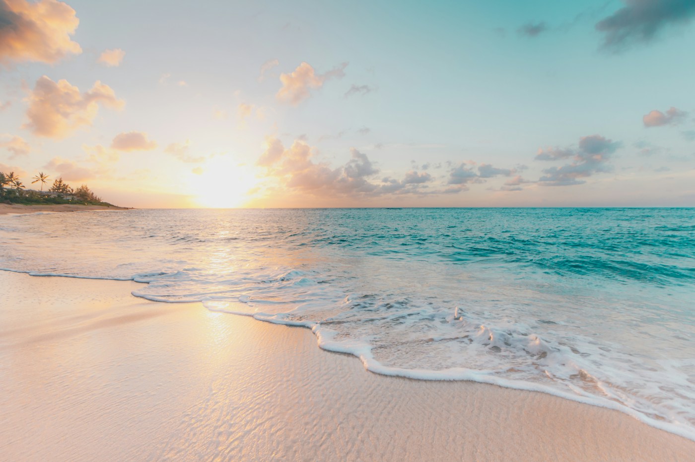 Soft sunrise over a sandy beach and gentle ocean waves